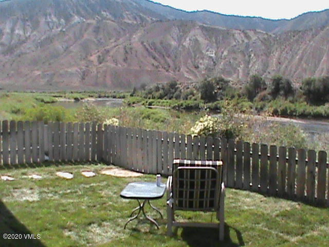 a view of a chairs and table in the backyard