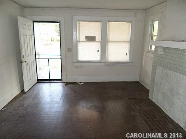 1705 Beatties Ford Road Charlotte, NC 28216 - Photo 2 of 6 a view of an empty room with wooden floor and a window