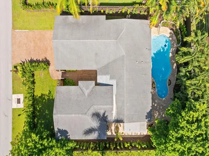 an aerial view of a house with swimming pool and garden