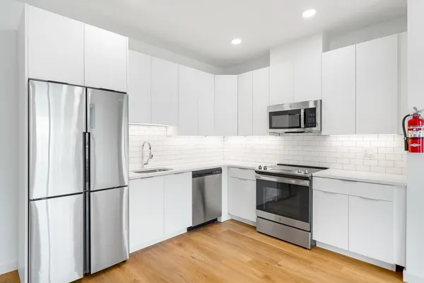 a kitchen with stainless steel appliances a refrigerator stove and microwave