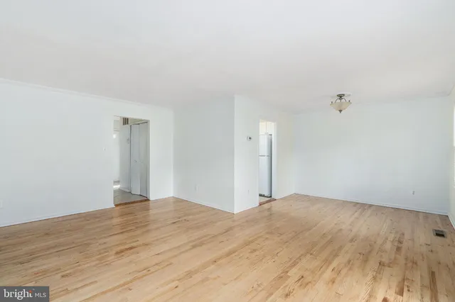 a view of a room with wooden floor and white walls
