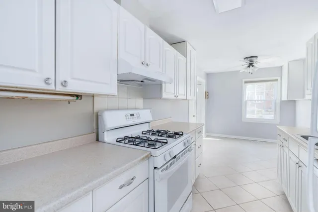 a kitchen with white cabinets and appliances