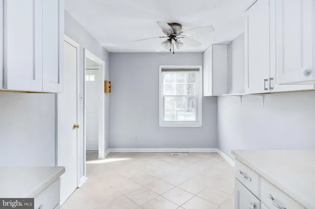 a view of an empty room and window with cabinet