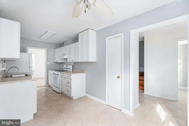 a kitchen with white cabinets and white appliances