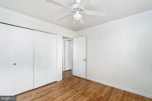 a view of an empty room with closet and a ceiling fan