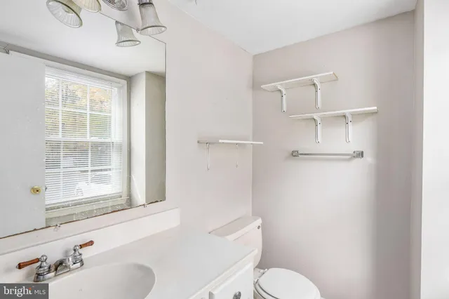 a bathroom with a toilet sink a mirror and shower