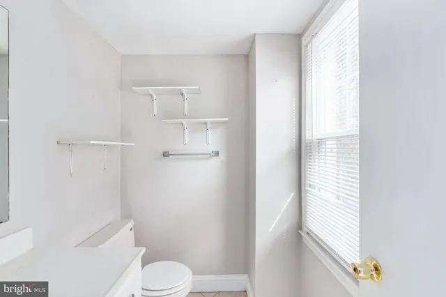 a white toilet sitting next to a bathroom sink and vanity