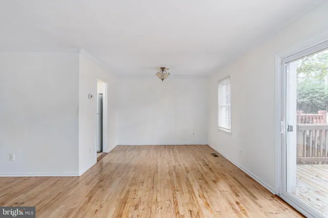 a view of a big room with wooden floor and windows