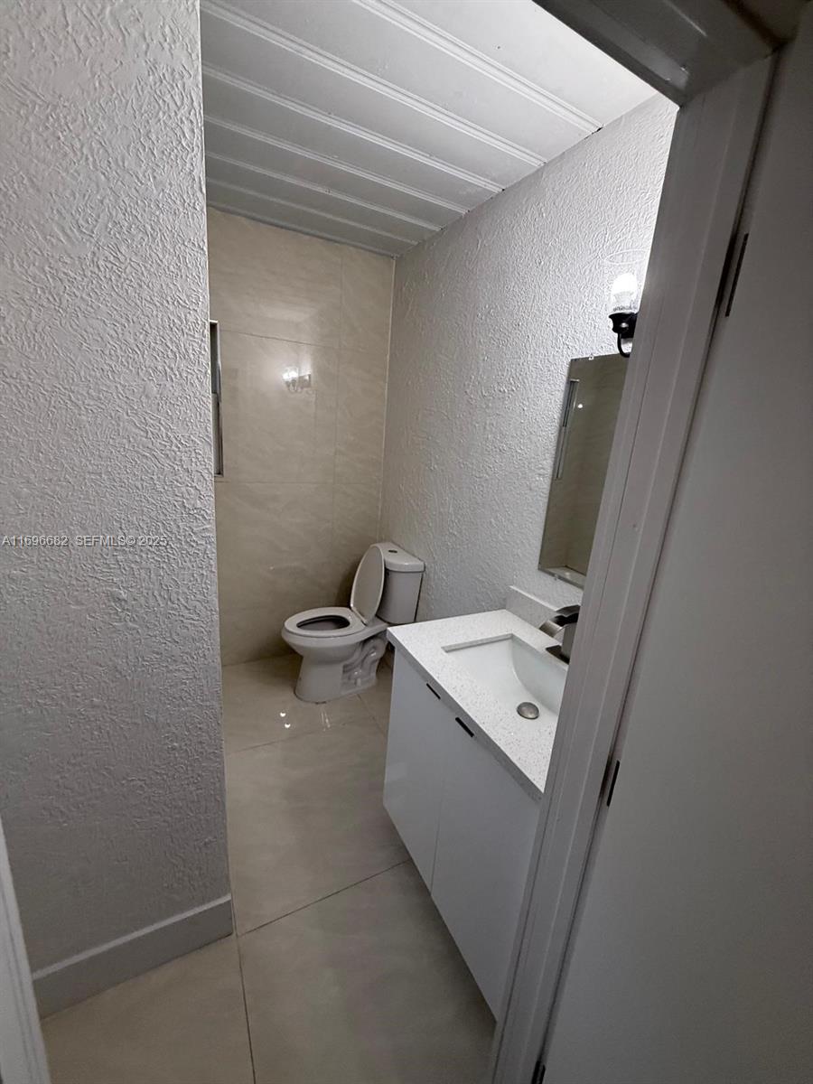 501 Wendell Road, Unit A Fort Pierce, FL 34950 - Photo 16 of 17 a bathroom with a toilet sink and mirror