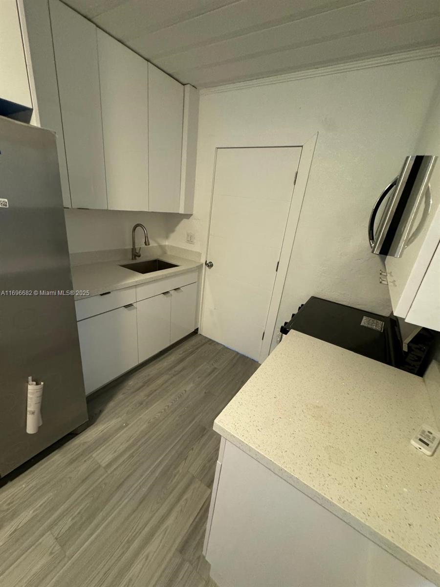 501 Wendell Road, Unit A Fort Pierce, FL 34950 - Photo 4 of 17 a kitchen with a sink a stove and white cabinets