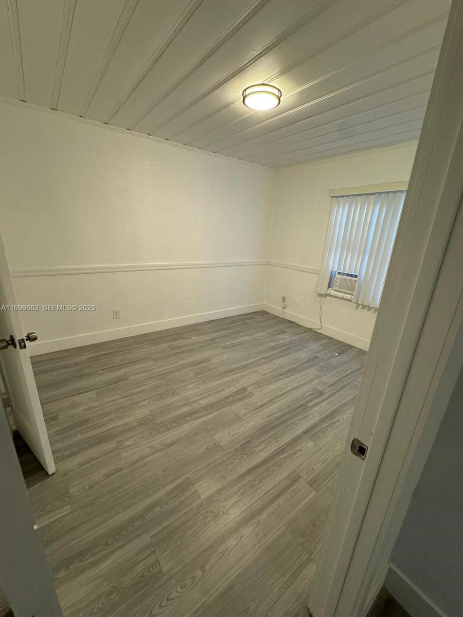 501 Wendell Road, Unit A Fort Pierce, FL 34950 - Photo 9 of 17 a view of a room with wooden floor and a window