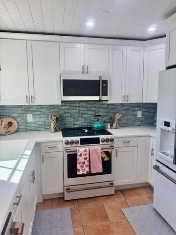 a kitchen with stainless steel appliances granite countertop a stove a sink and a microwave