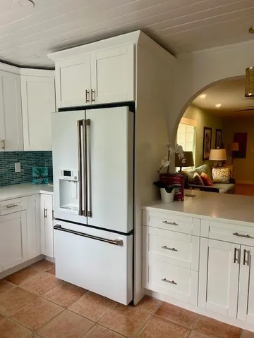 a kitchen with cabinets a refrigerator and a sink