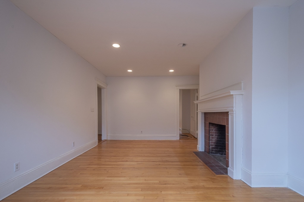 2 Newport Road, Unit 5 Cambridge, MA 02140 - Photo 11 of 18 a view of empty room with wooden floor and fireplace