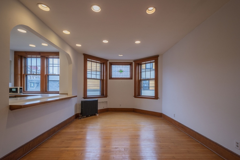 2 Newport Road, Unit 5 Cambridge, MA 02140 - Photo 7 of 18 a view of an empty room with wooden floor and a window