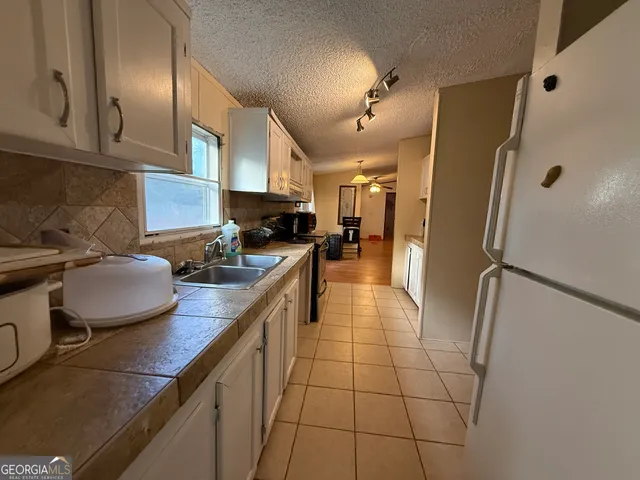 a kitchen with stainless steel appliances granite countertop a sink refrigerator and cabinets