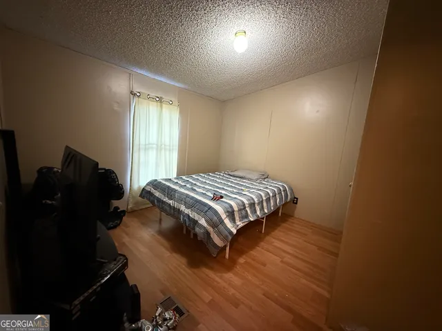 a bedroom with a bed and wooden floor