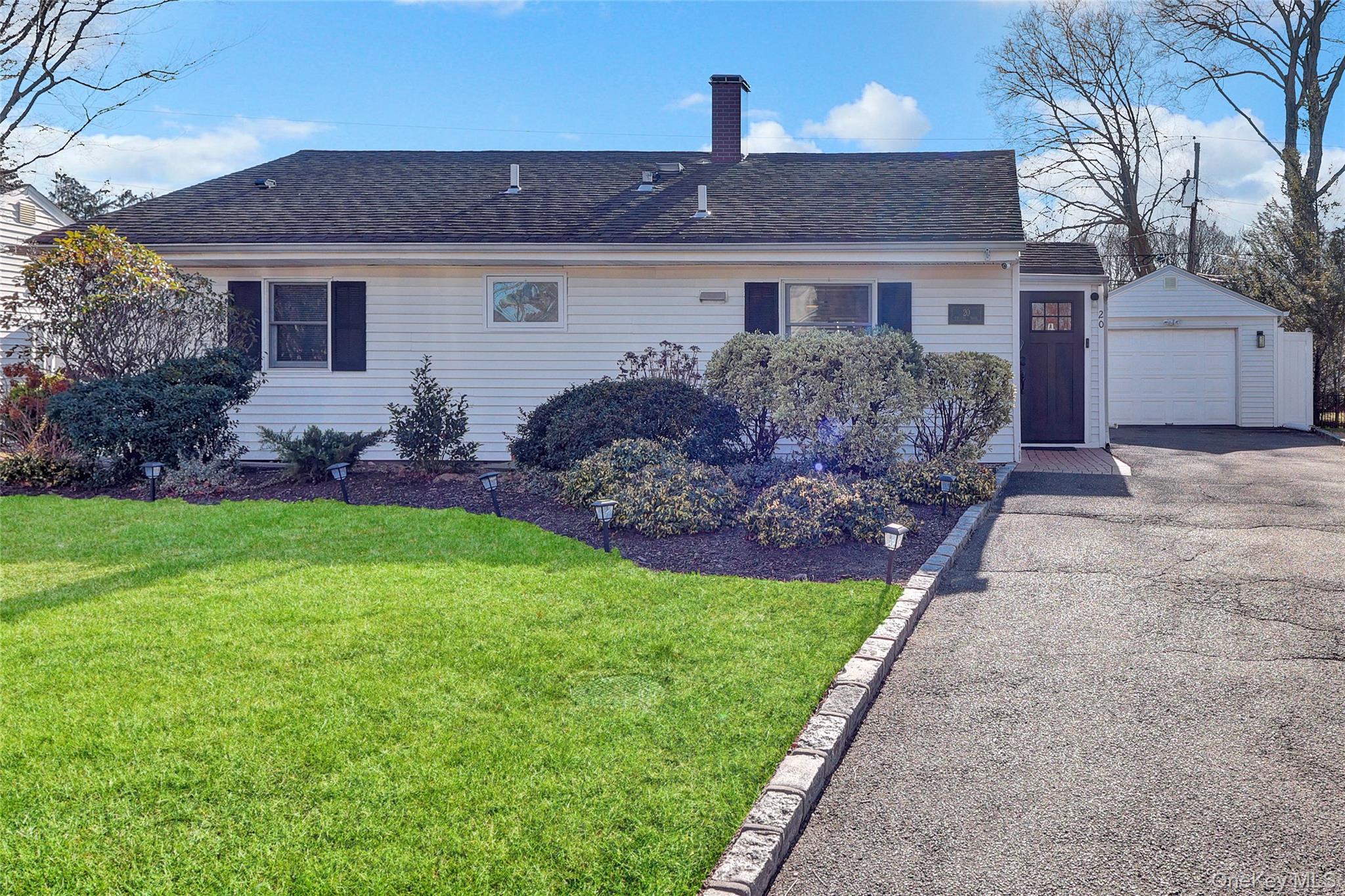a front view of house with a garden and patio