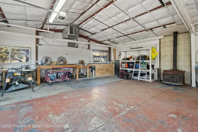 a view of a garage with wooden table and chairs in a room