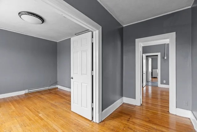 a view of an empty room with wooden floor