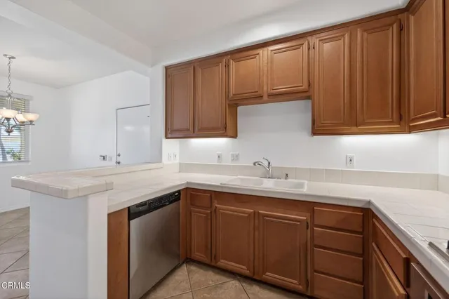 a kitchen with stainless steel appliances granite countertop a sink dishwasher stove and cabinets with wooden floor