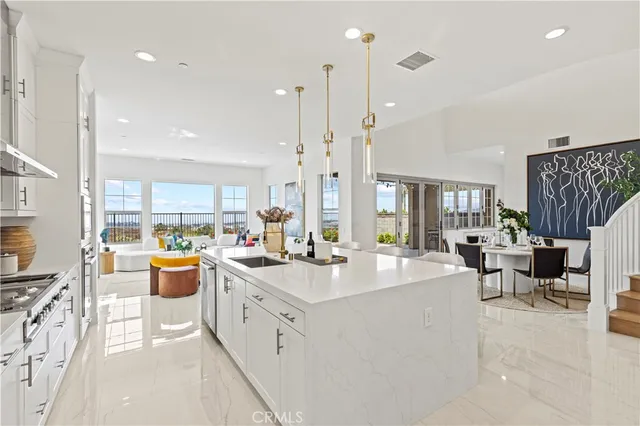 a large white kitchen with cabinets and a window