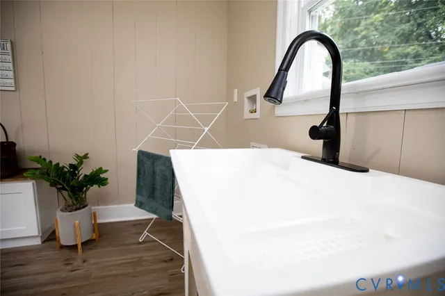 a view of an empty room with wooden floor and window