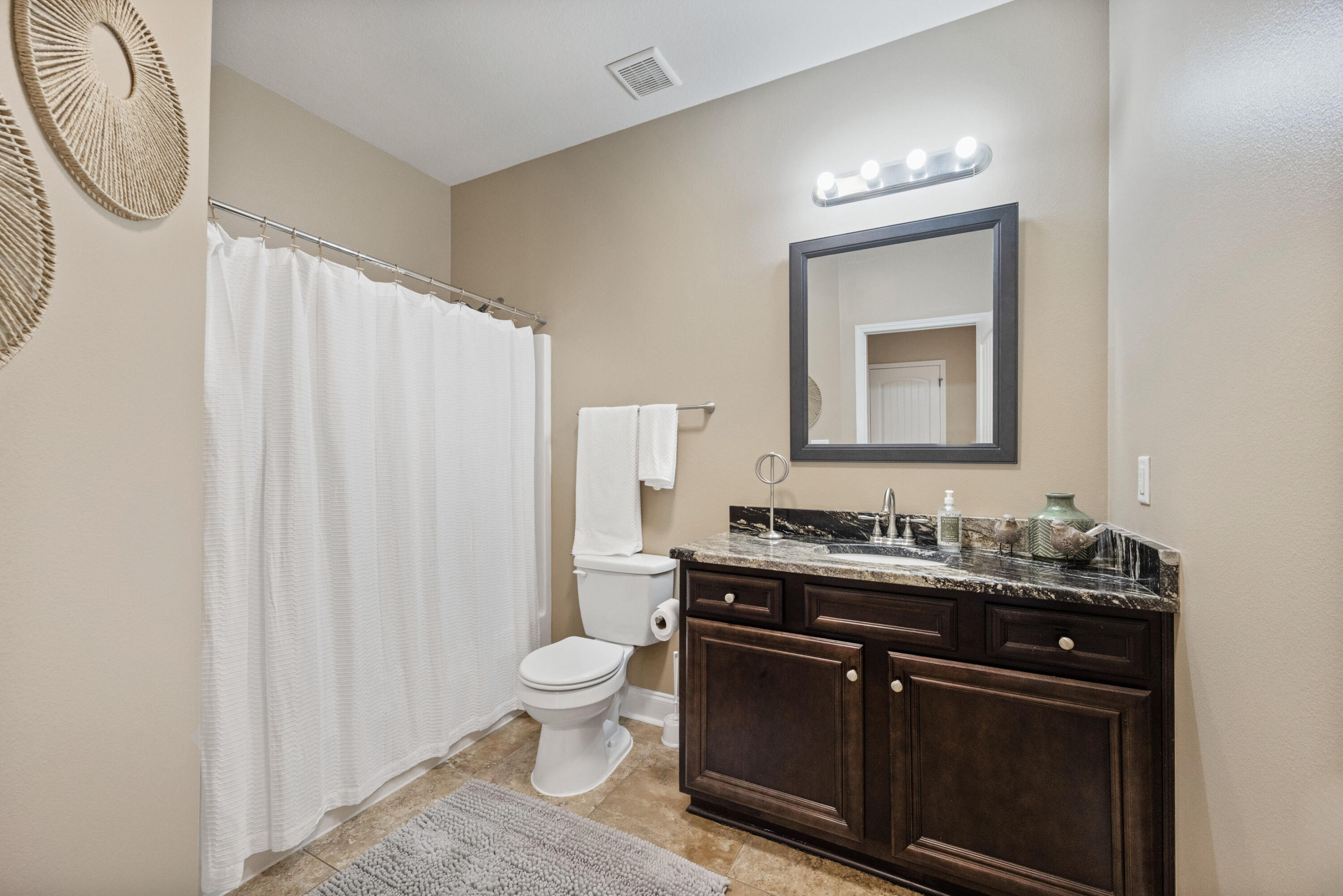 5774 Wayne Rogers Road Crestview, FL 32539 - Photo 43 of 63 a bathroom with a toilet sink and mirror