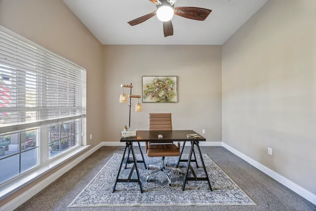 a view of swimming pool with lawn chairs and large trees