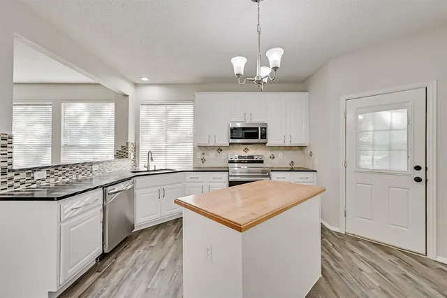 a kitchen with stainless steel appliances a stove sink and microwave
