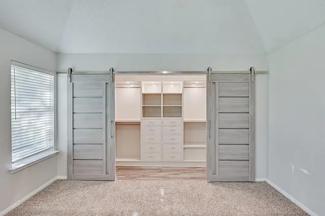 a view of walk in closet with empty racks