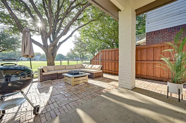 a view of a patio with table and chairs and floor to ceiling window and wooden fence