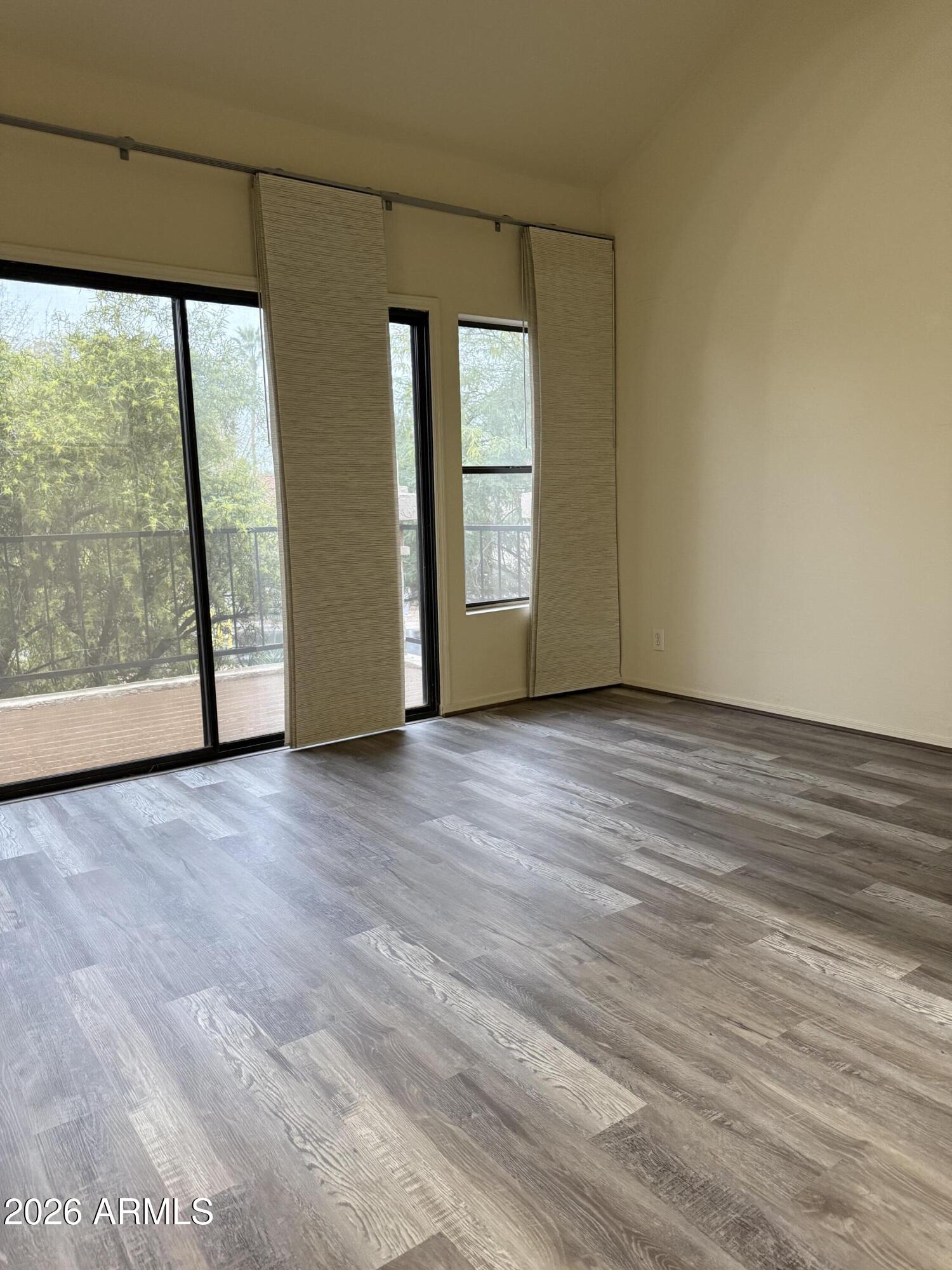 9705 East Mountain View Road, Unit 1019 Scottsdale, AZ 85258 - Photo 19 of 32 a view of an empty room with wooden floor and a window