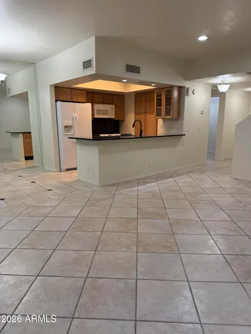 a living room with stainless steel appliances kitchen island granite countertop a sink and cabinets