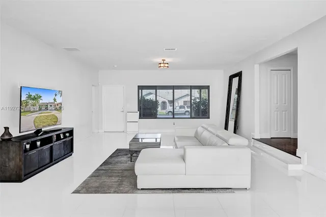 a kitchen with granite countertop white cabinets and a window