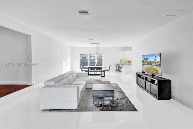 a kitchen with stainless steel appliances kitchen island granite countertop a sink and white cabinets