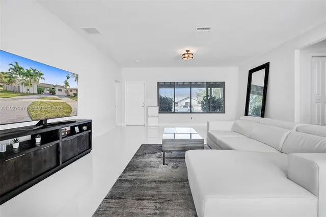 a living room with furniture and floor to ceiling window