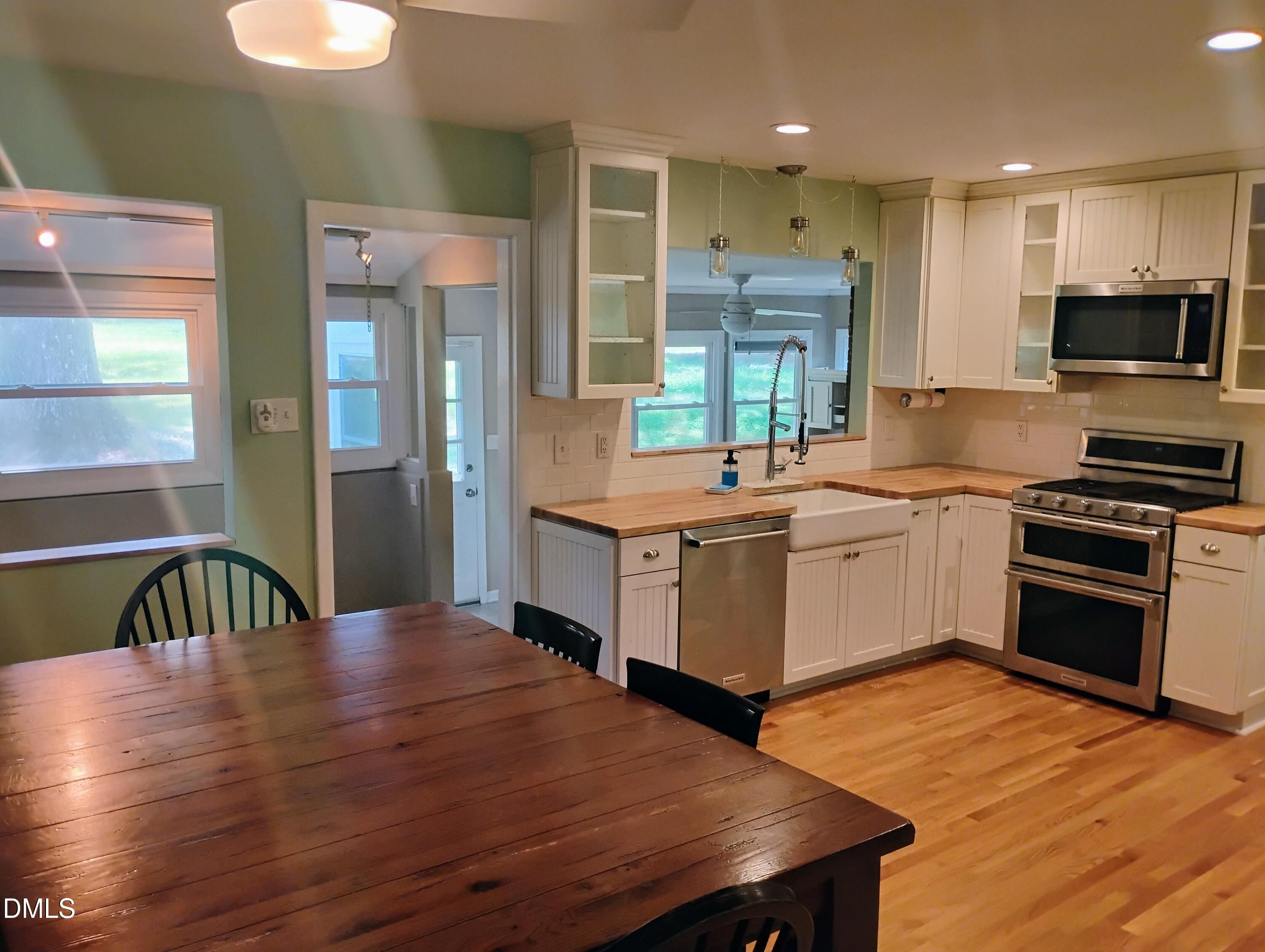 6121 Yates Mill Pond Road Raleigh, NC 27606 - Photo 3 of 18 a kitchen with a table chairs sink and cabinets