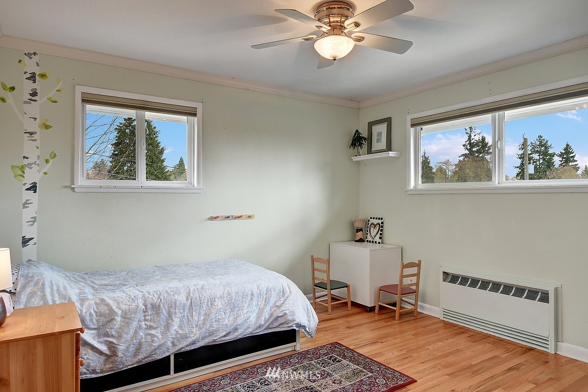 8202 37th Avenue Southwest Seattle, WA 98126 - Photo 11 of 27 a bedroom with a bed and a chandelier