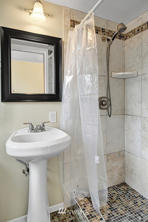 8202 37th Avenue Southwest Seattle, WA 98126 - Photo 16 of 27 a bathroom with a sink a mirror and shower
