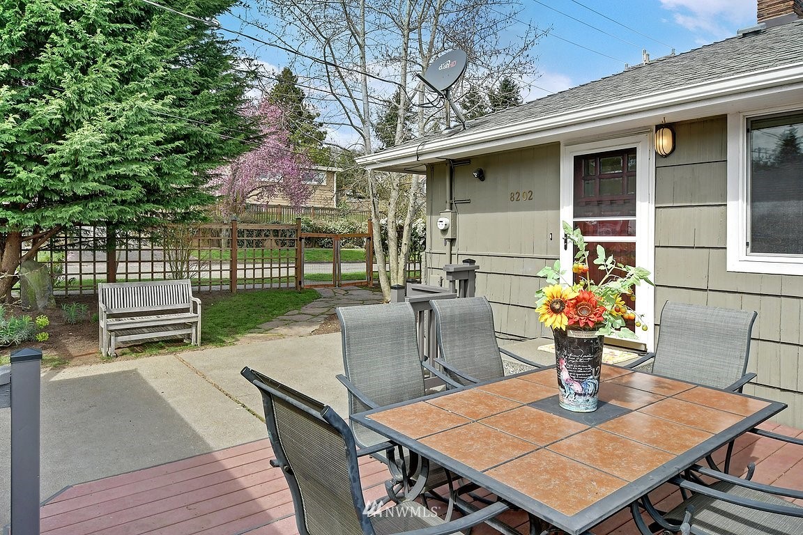 8202 37th Avenue Southwest Seattle, WA 98126 - Photo 20 of 27 a view of a patio with table and chairs potted plants with wooden floor and fence