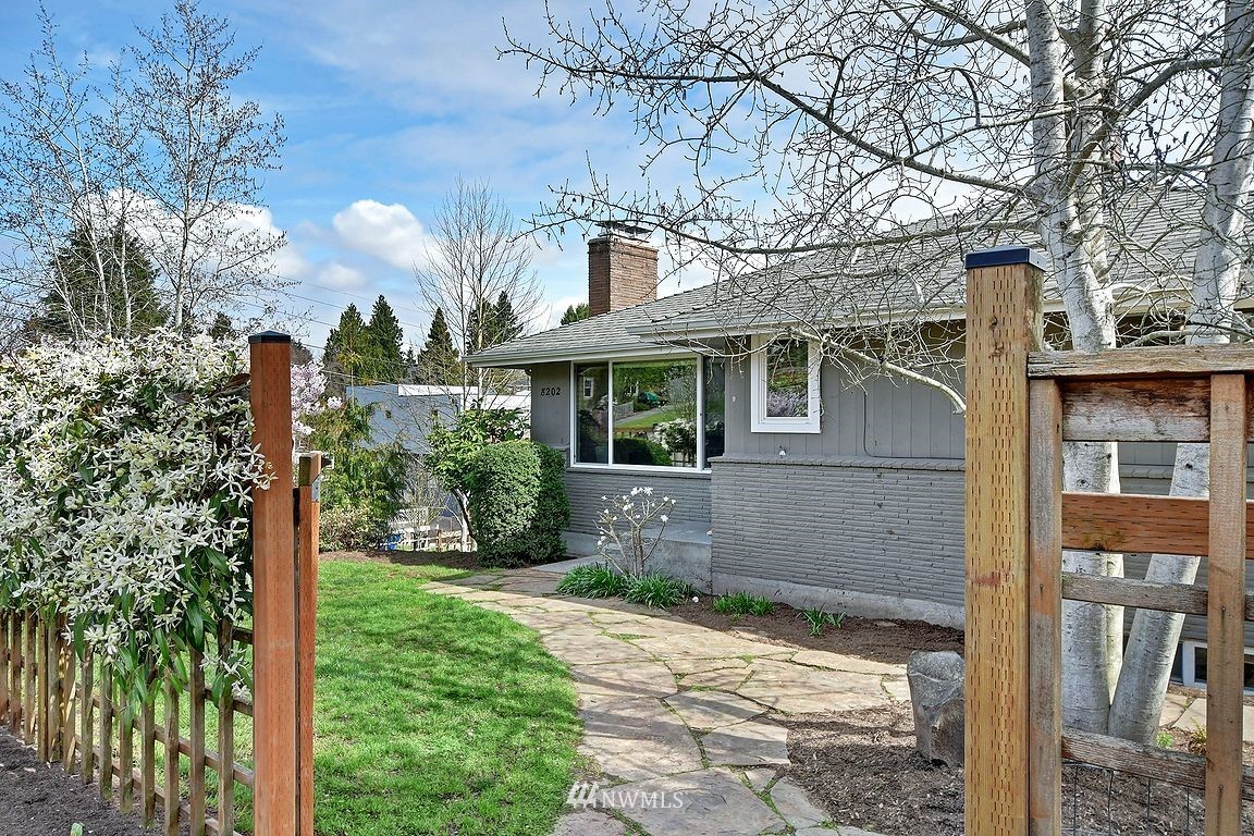 8202 37th Avenue Southwest Seattle, WA 98126 - Photo 23 of 27 a view of a white house next to a yard with big trees