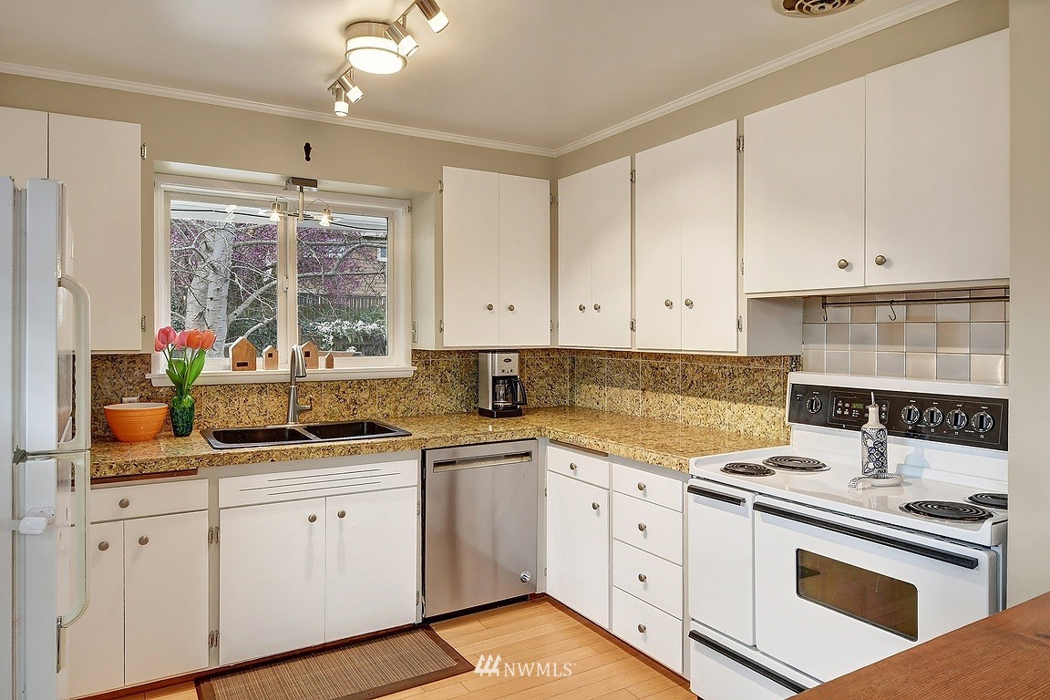 8202 37th Avenue Southwest Seattle, WA 98126 - Photo 7 of 27 a kitchen with white cabinets and white appliances