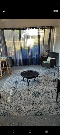 a view of a porch with furniture and a yard