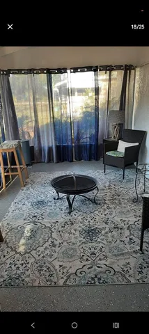 a view of a porch with furniture and a yard