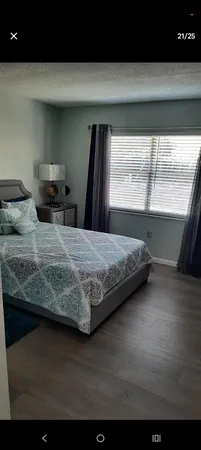 a bedroom with a bed and large window