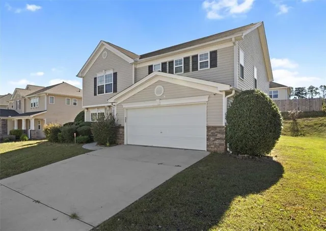 a front view of a house with a yard and garage