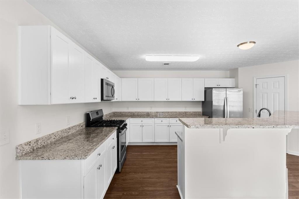 2068 White Top Road Southeast Lawrenceville, GA 30045 - Photo 15 of 41 a kitchen with stainless steel appliances granite countertop a sink stove and cabinets