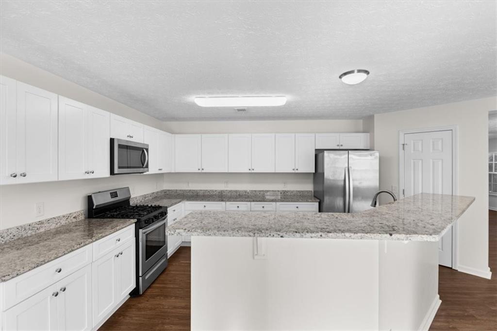 2068 White Top Road Southeast Lawrenceville, GA 30045 - Photo 17 of 41 a kitchen with stainless steel appliances granite countertop a sink stove and refrigerator