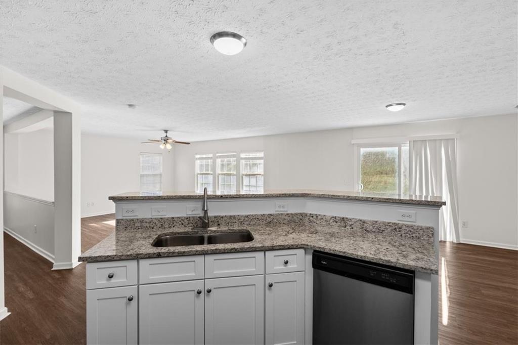2068 White Top Road Southeast Lawrenceville, GA 30045 - Photo 18 of 41 a kitchen with granite countertop a sink and white cabinets